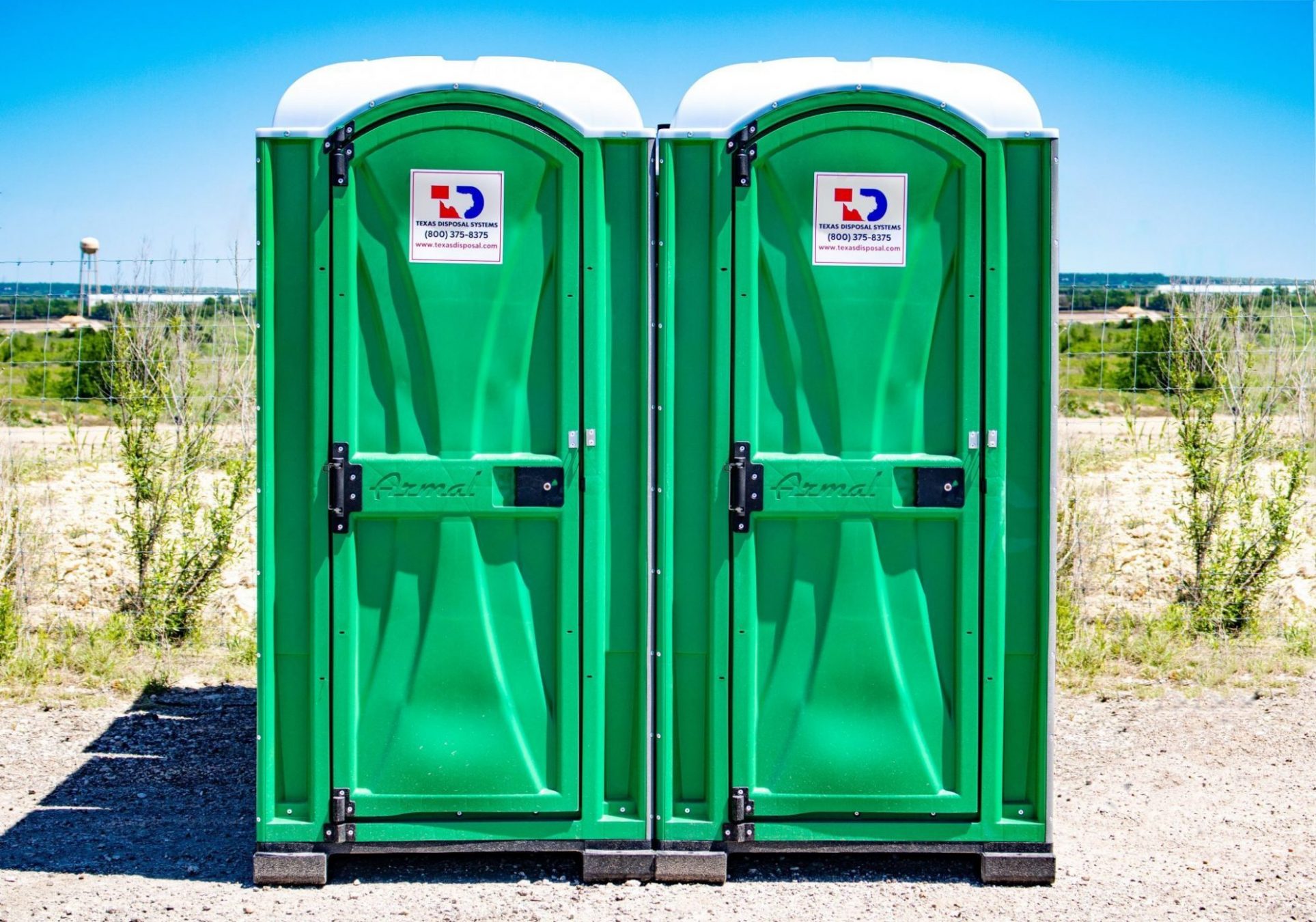 Two green Texas Disposal Systems portable restrooms