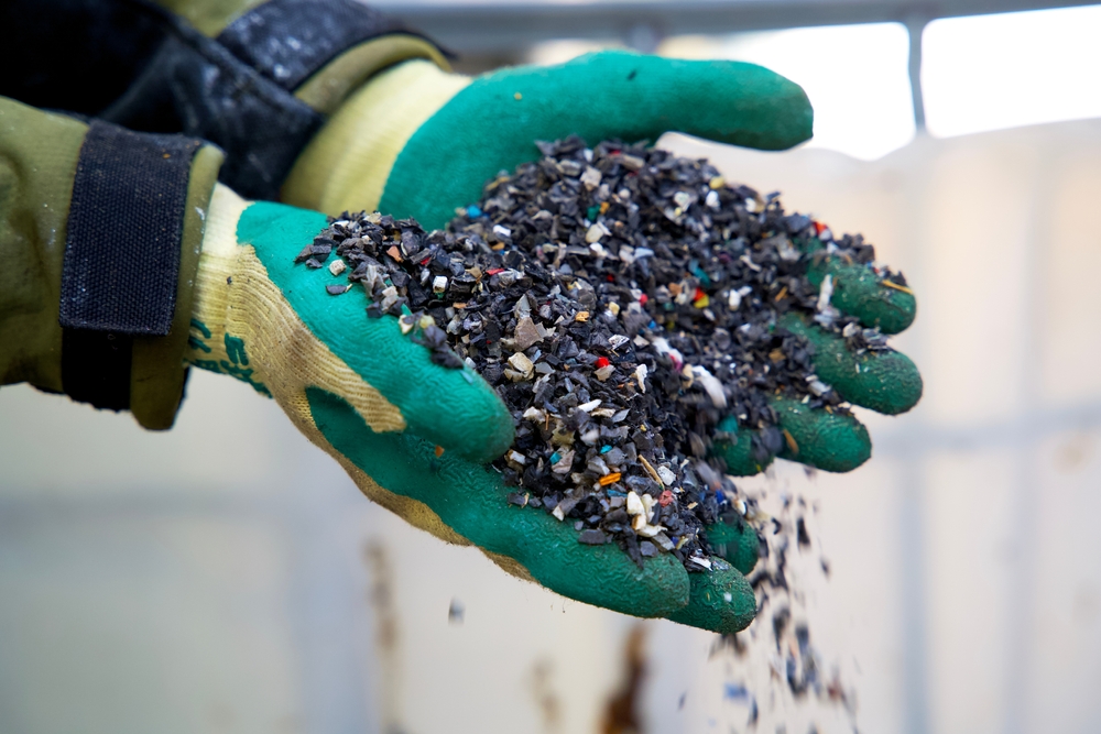 gloved hands holding plastic granulate
