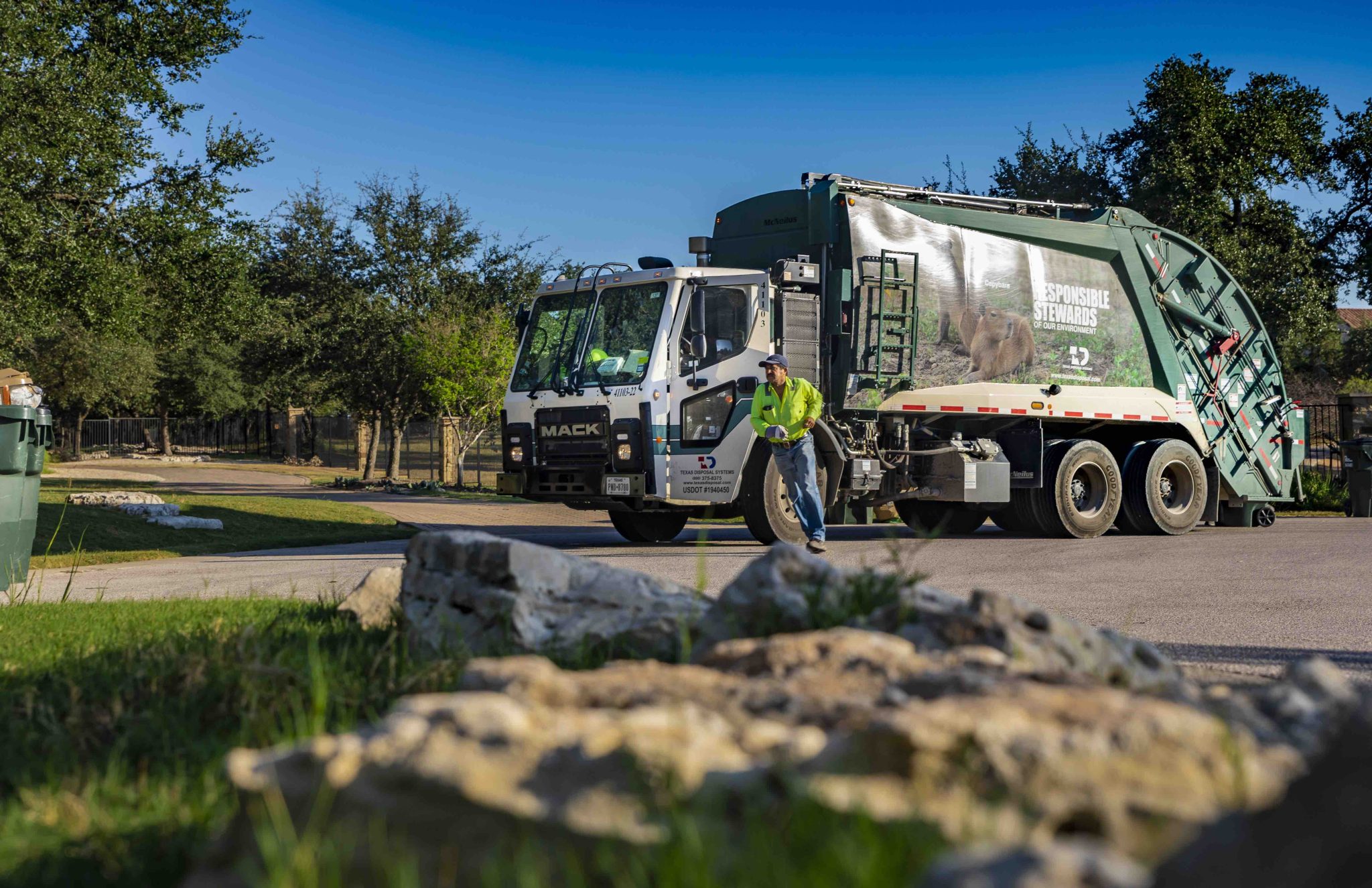Residential McNeilus Truck with TDS Employee Running to Service a Residential Cart