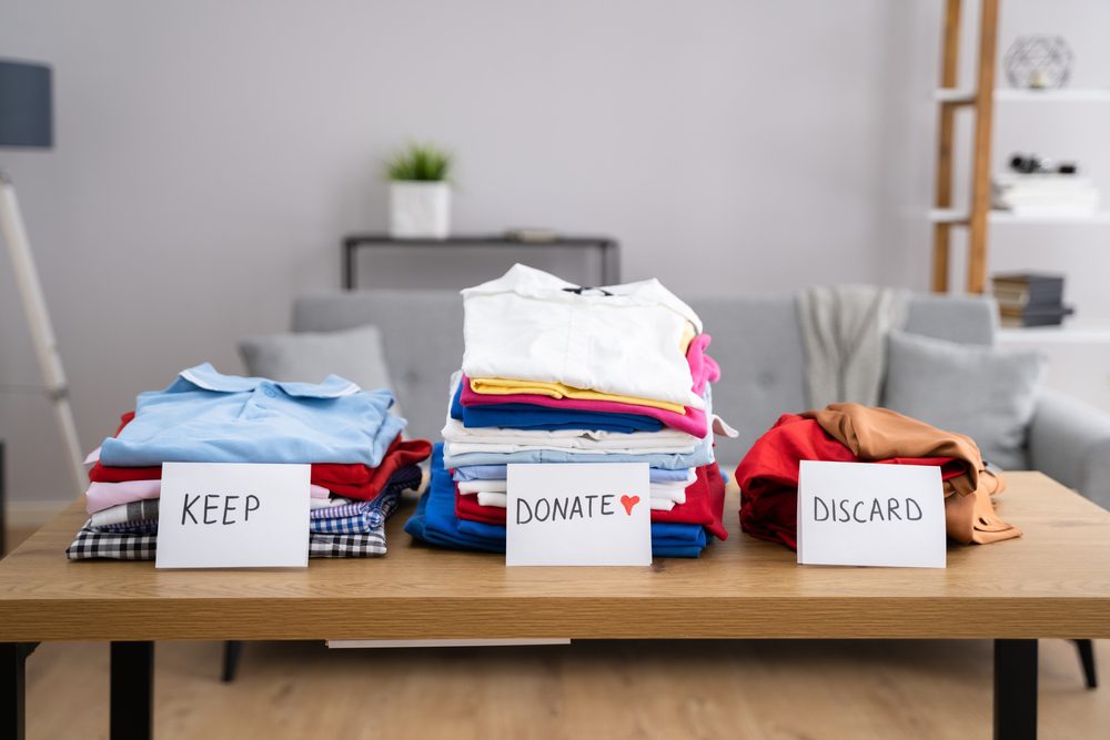 Keep, donate, and discard piles of clothing from a house cleanout