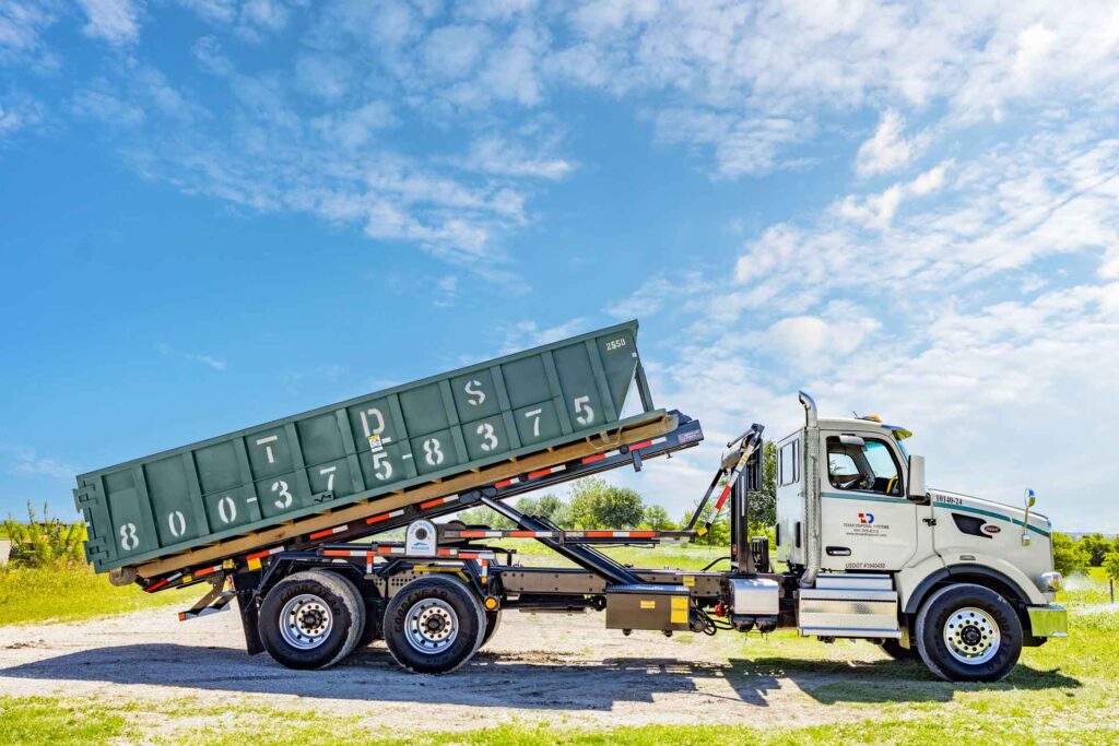 Green TDS roll off dumpster elevated on back of TDS truck