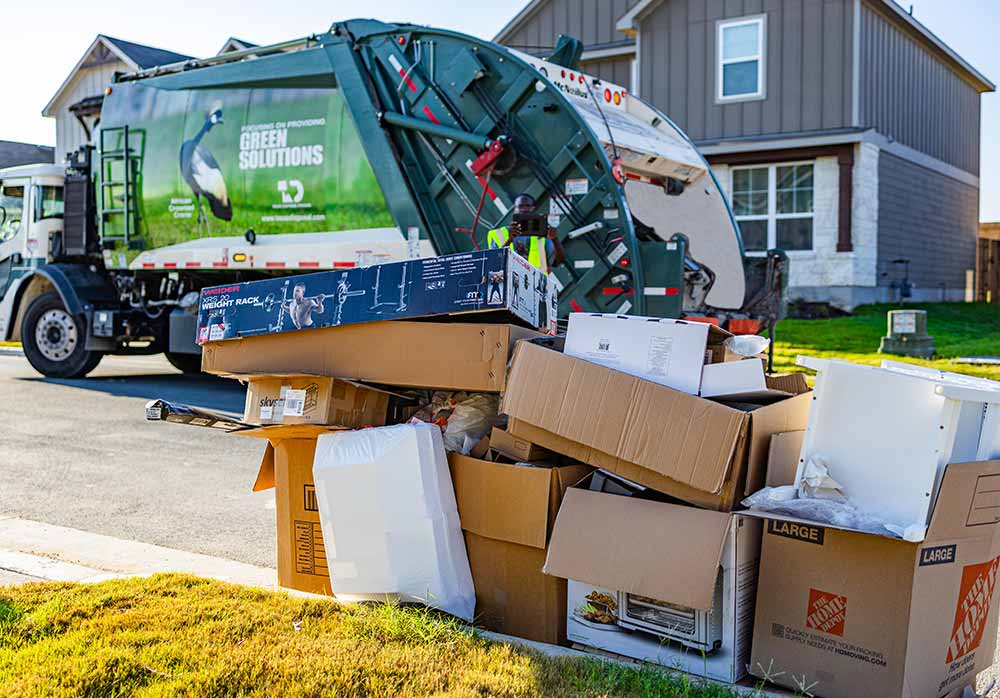 Bulky items in front of TDS green trash pick up truck