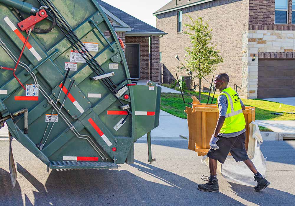 TDS trash truck with one employee putting things into the truck
