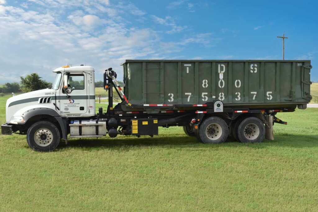 Green 30 yard TDS dumpster on back of TDS truck in field