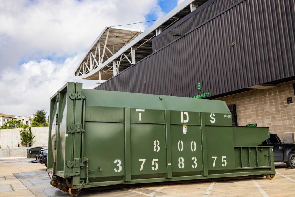 Green TDS compactor roll off dumpster at Austin FC Q2 Stadium