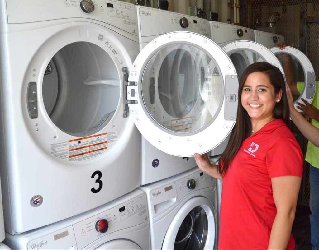 A TDS employee opening a laundry unit and smiling