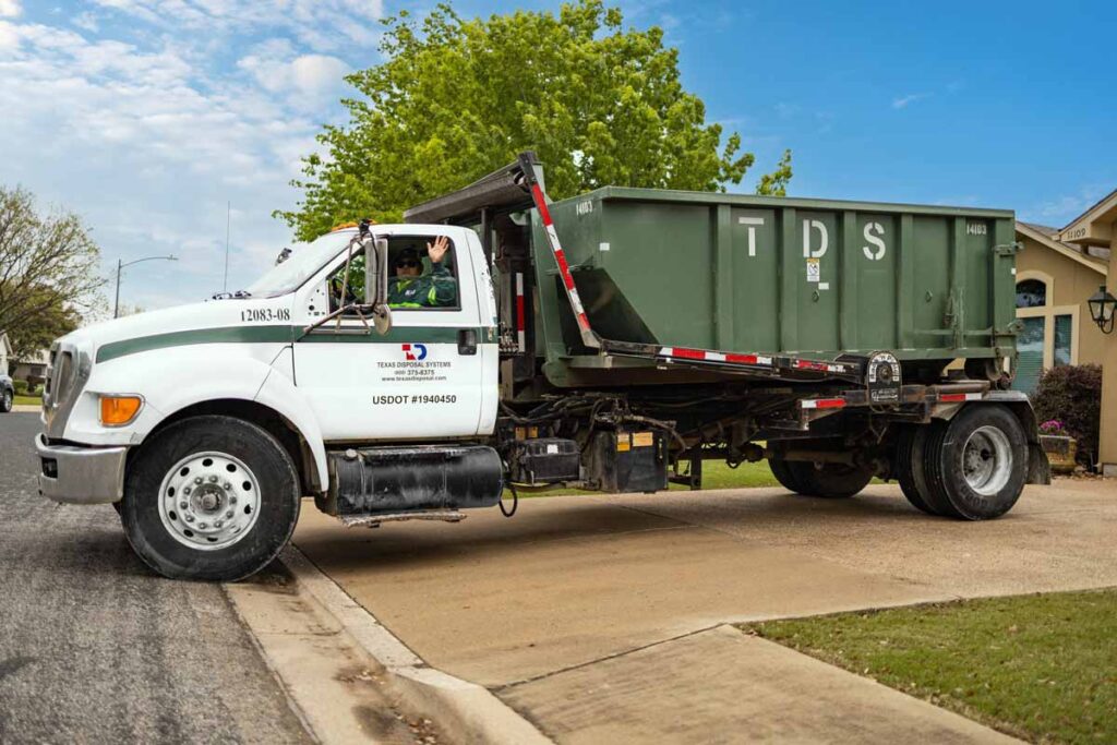 TDS green compactor roll off dumpster on TDS truck