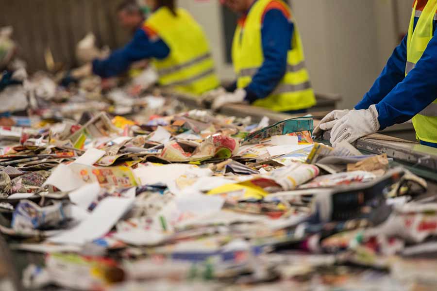 Workers sorting recycling material on conveyor belt at TDS Materials Recovery Facility (MRF)
