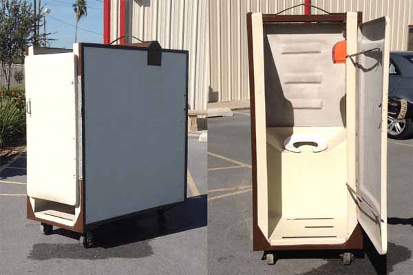 Two white portable restroom units with wheels attached at the bottom. The right portable restroom unit has the door open showcasing the toilet