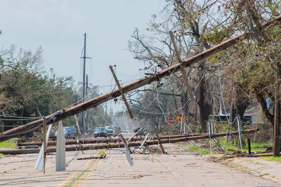 Knocked over powerline laying across a road after a natural disaster
