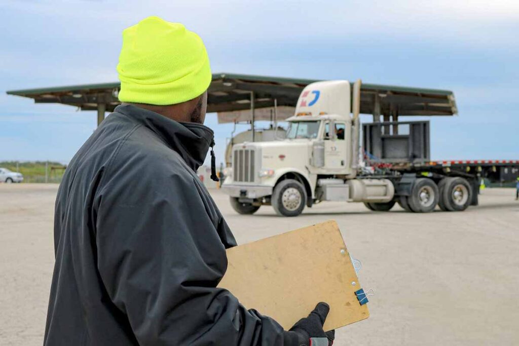 Texas Disposal Systems employee holding a clipboard with a TDS-branded Trailer in the background.