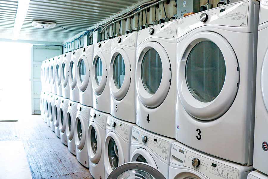 White TDS washer and dryers inside laundry trailer