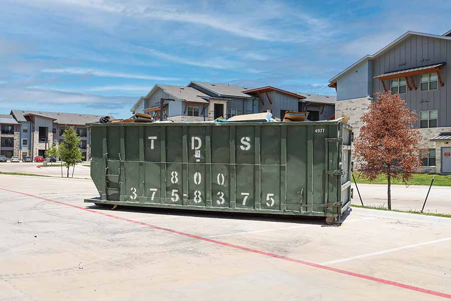 Green TDS roll off dumpster at apartment complex