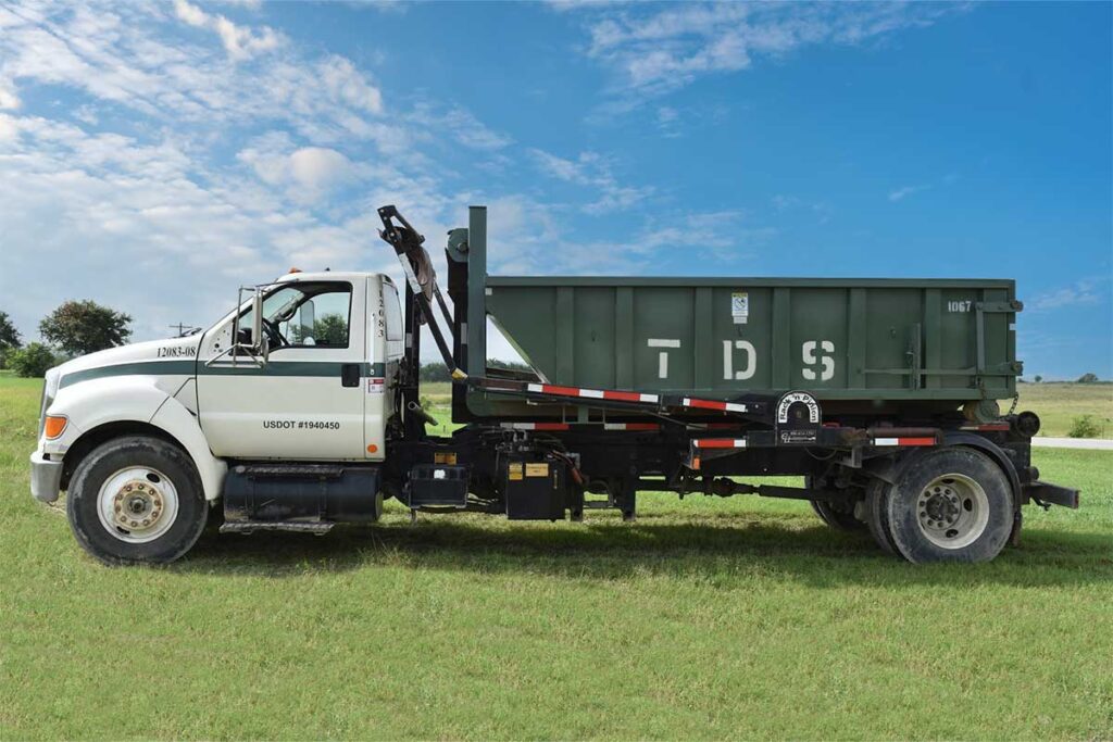 Green TDS mini roll off dumpster on TDS truck