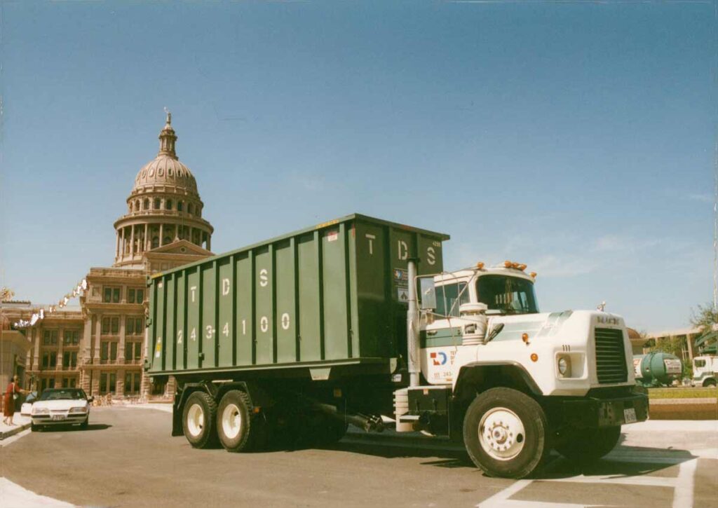 Old image of Texas Disposal Systems Dumpster Truck in front of Texas Capitol