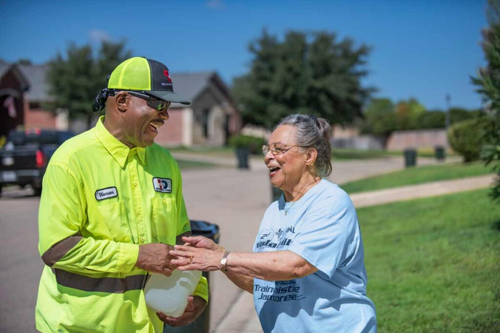 Texas Disposal Systems Employee shaking hands with happy resident
