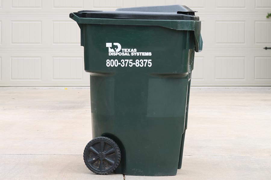 TDS green trash cart in front of garage door
